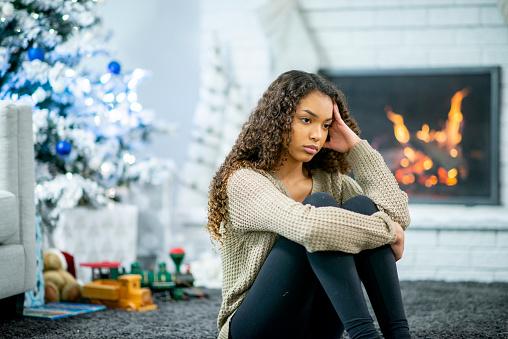girl sitting in front of fireplace looking stressed